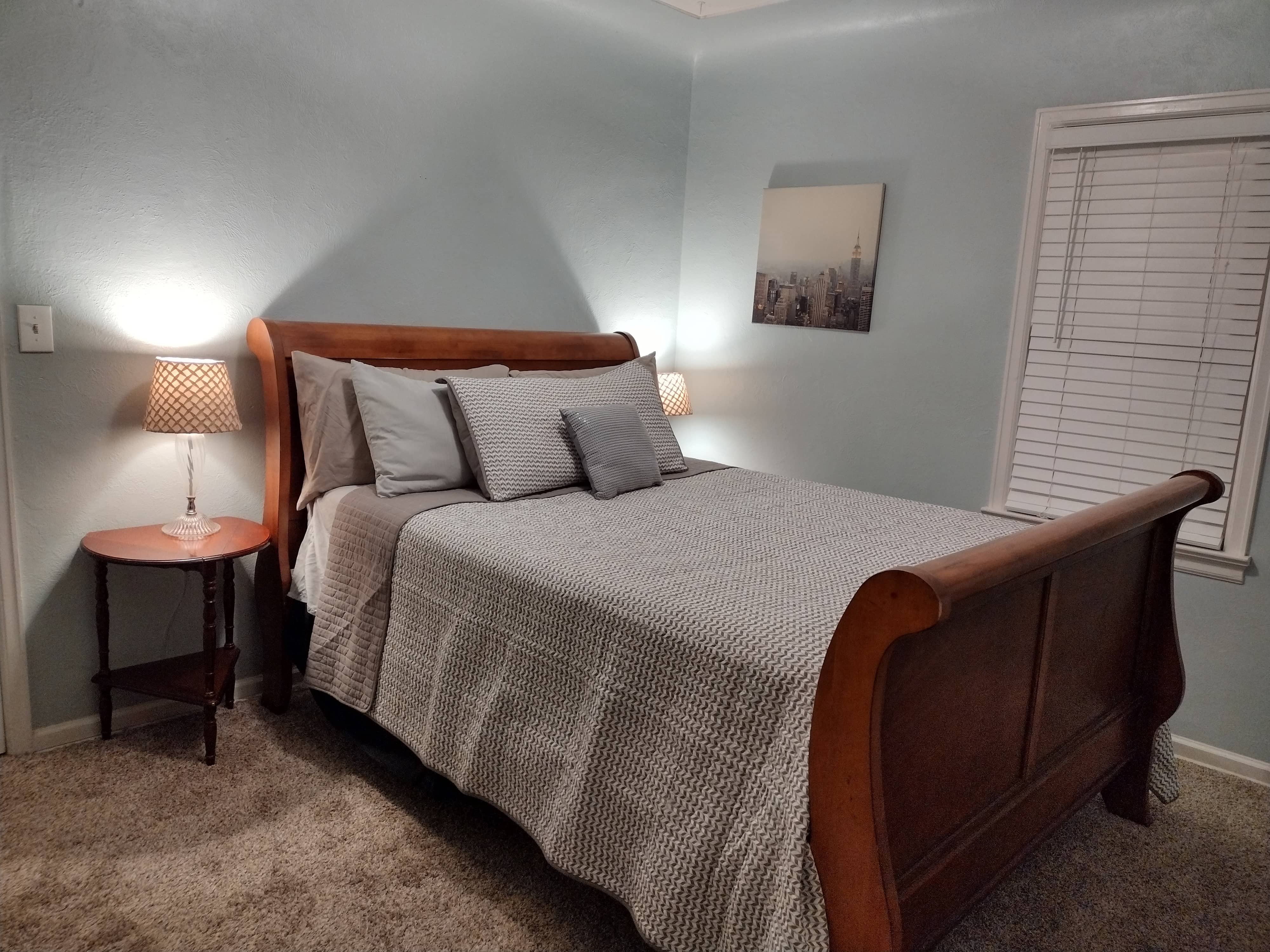 Queen sleigh bed in minimalist colors with a nice quilt on top