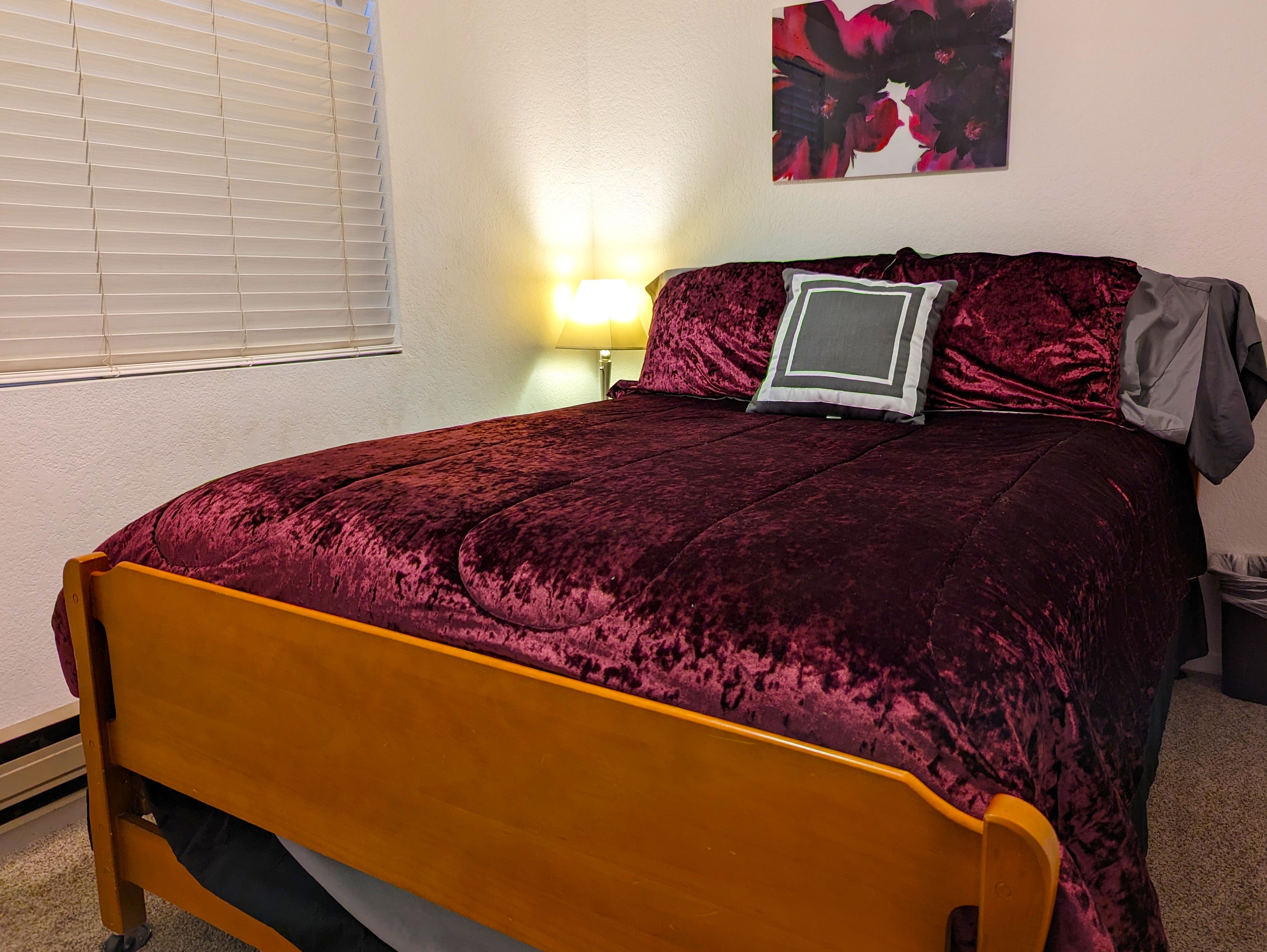 Queen bed in a bright bedroom setting