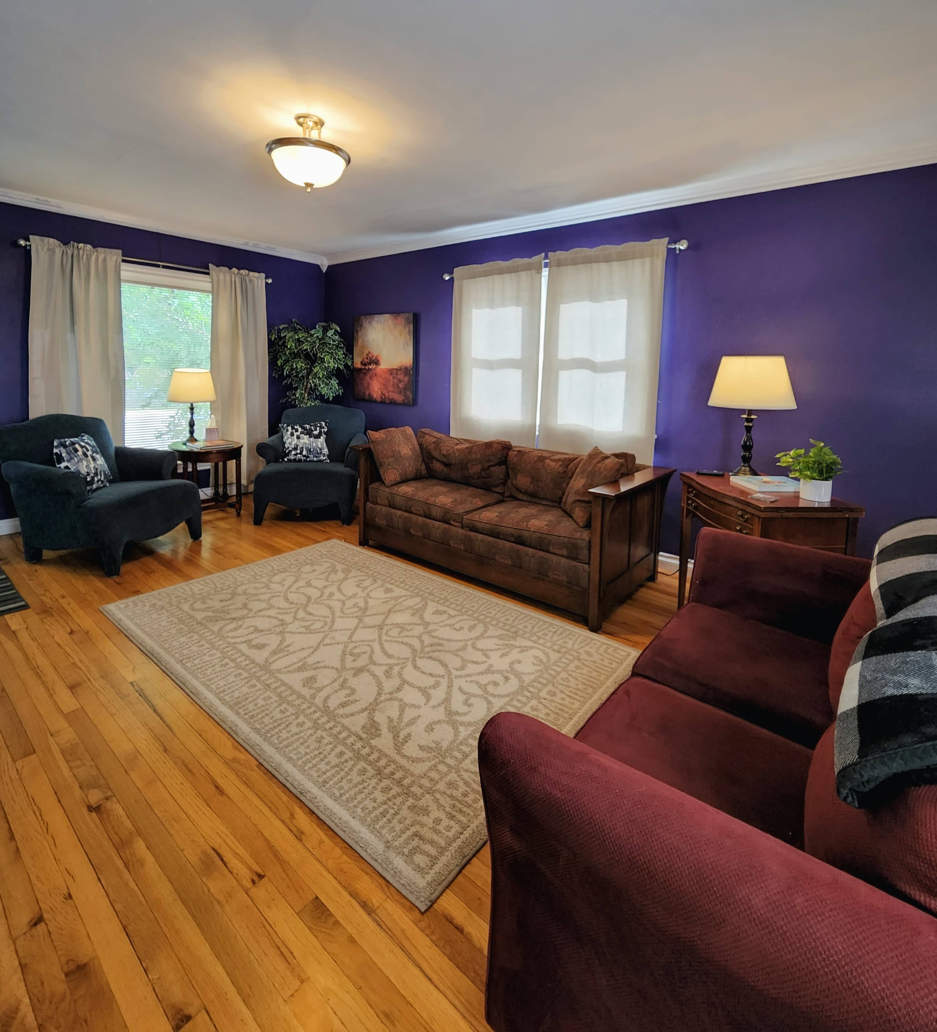 Living room with couches, loveseat, and chairs seating for 8