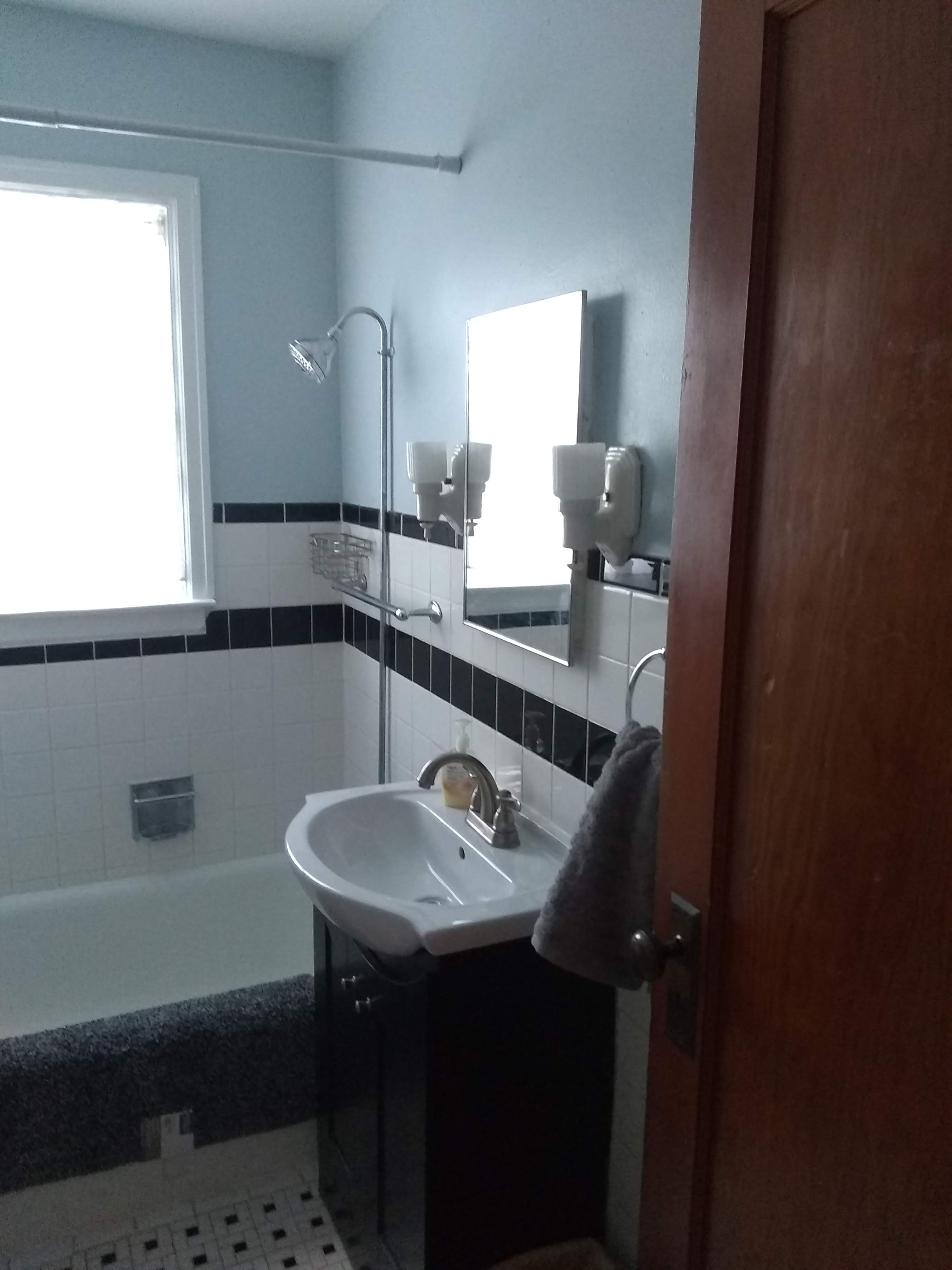 Bathroom with bathtub and shower, toilet and sink, clean and white