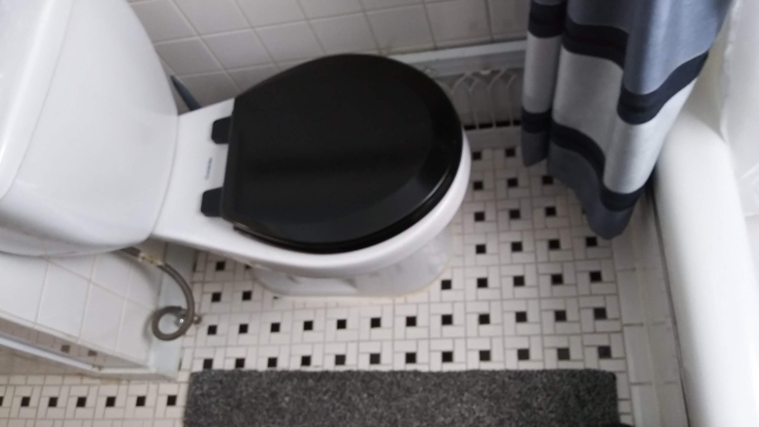 Toilet with floor mats in bathroom, well maintained