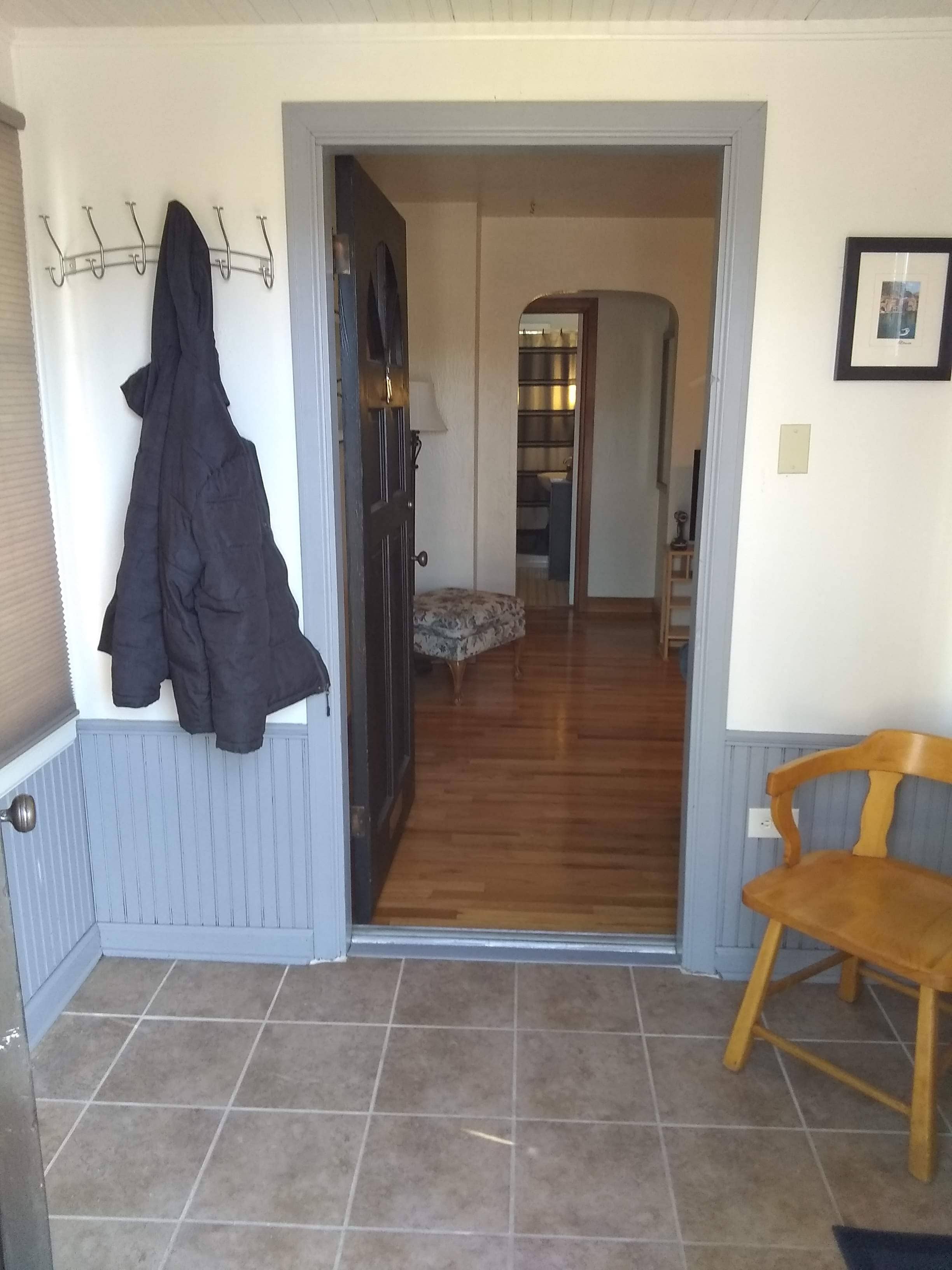 Tile entrance leading to hardwood floor inside