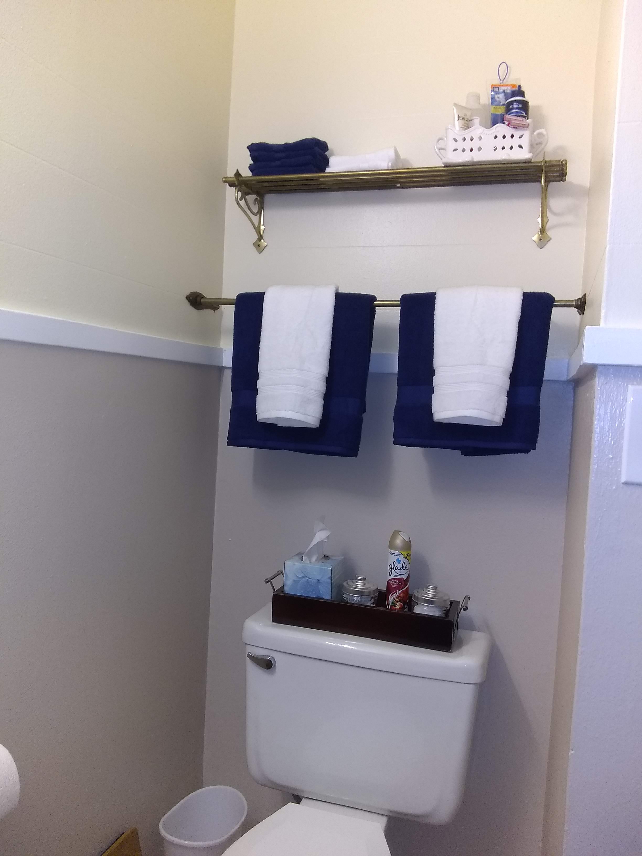 Bathroom with toilet, fully stocked with decorative towels